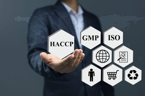 Businessman holding a HACCP certification sign certifying that the food has been verified as being safe for consumption and other standards such as ISO and GMP.